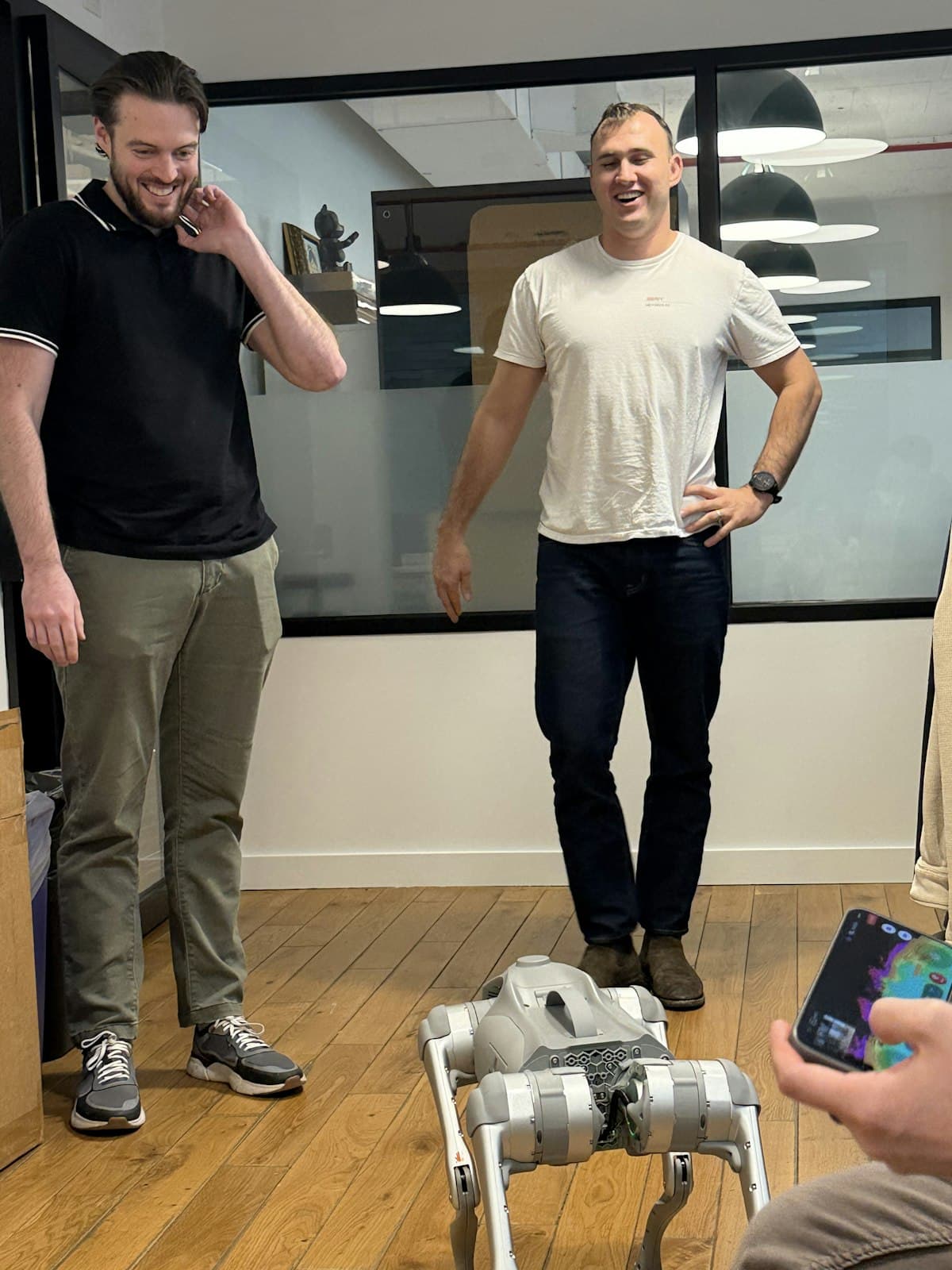Two teammates looking at a robot dog